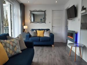 sala de estar con sofá azul y espejo en Chalet 174 Glan Gwna Park Caernarfon, en Caeathro