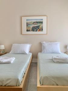 two beds sitting next to each other in a room at Lovely apartment by the sea 2 ….. in Epanomi