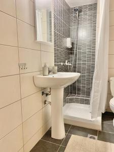 a bathroom with a sink and a shower and a toilet at Lovely apartment by the sea 2 ….. in Epanomi