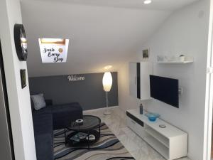 uma sala de estar com um sofá e uma televisão em Apartman prvi red do mora em Sveti Filip i Jakov