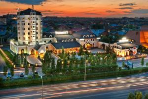un grand bâtiment blanc avec une tour d'horloge la nuit dans l'établissement Boutique Hotel Traditional, à Astana