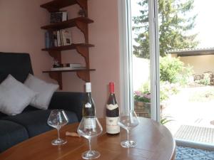 zwei Flaschen Wein auf einem Tisch mit Weingläsern in der Unterkunft L'Escale Dijonnaise in Dijon