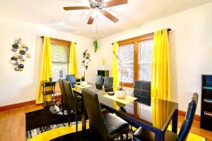 uma sala de jantar com cortinas amarelas e uma mesa e cadeiras em The Amber Retreat - Brooklyn Centre Comfort - Charming Space for Families, Couples & Business Travelers Near Downtown - With 300MB WiFi, Parking & Self Check-In em Cleveland