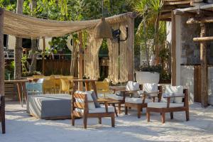 an outdoor dining area with chairs, tables and umbrellas at Villas Caracol in Holbox Island