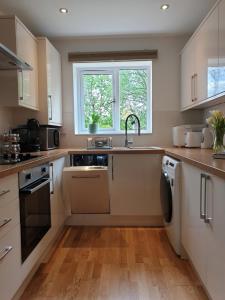 a kitchen with a sink and a dishwasher at Cheerful 1 private room-ensuite with free parking in Silverdale