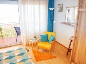 ein Wohnzimmer mit einem gelben Stuhl und einem Fenster in der Unterkunft Panoramico Apartment Opatija in Opatija
