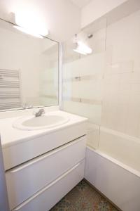 La salle de bains blanche est pourvue d'un lavabo et d'une douche. dans l'établissement Hossegor - Vue Océan - Plage - Couple - Famille, à Soorts-Hossegor