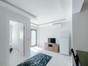 sala de estar blanca con TV y puerta en Turgutreis Apart Otel, en Bodrum City