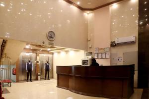 two men standing at the reception desk in a lobby at شقق أمواج للشقق المخدومه in Al Jubail