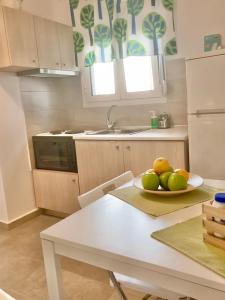 a kitchen with a plate of fruit on a table at Lovely apartment by the sea 2 ….. in Epanomi