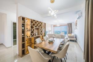 a dining room and living room with a table and chairs at Vila katune 2022 in Ulcinj