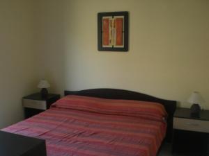 1 dormitorio con 1 cama, 2 mesitas de noche y una foto en Villa Solare, en Marina di Noto