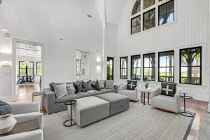 ein Wohnzimmer mit Sofa, Stühlen und Fenstern in der Unterkunft Club Cottage 6 in Kiawah Island