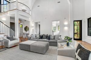 ein Wohnzimmer mit einem grauen Sofa und Stühlen in der Unterkunft Club Cottage 6 in Kiawah Island