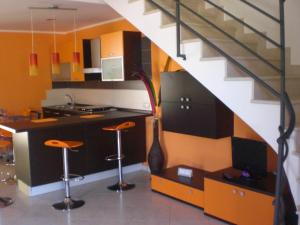 una cocina con escalera y una cocina con taburetes en Villa Solare, en Marina di Noto