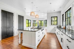 eine Küche mit weißen Schränken und einer großen Insel in der Unterkunft Club Cottage 6 in Kiawah Island + 46 Fotos