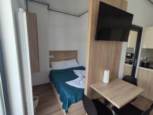 a small room with a bed and a table with a television at Sea & Sunset Studio in Mamaia Sat/Năvodari