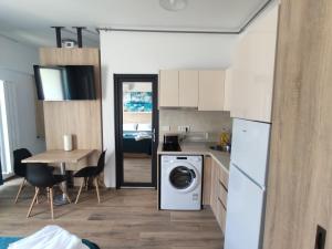 a kitchen with a table and a washing machine in a room at Sea & Sunset Studio in Mamaia Sat/Năvodari +11 photos