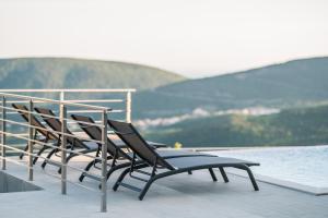 a group of chairs sitting on the edge of a balcony at Vila katune 2022 in Ulcinj