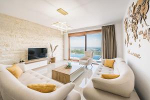 a living room with two white couches and a tv at Vila katune 2022 in Ulcinj