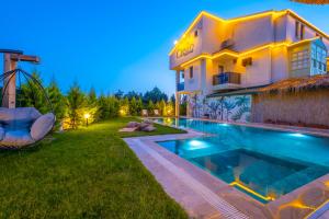 a villa with a swimming pool in front of a house at Ciello Suites Hotel in Fethiye