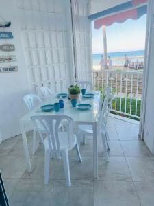 einen weißen Tisch und Stühle mit Meerblick in der Unterkunft Bello Horizonte Frontbeach in Salou