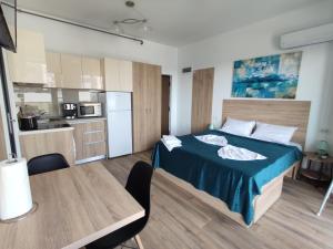 a bedroom with a bed and a table and a kitchen at Sea & Sunset Studio in Mamaia Sat/Năvodari