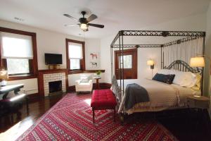 1 dormitorio con cama con dosel y alfombra roja en Louisville Bourbon Inn en Louisville