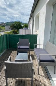 a patio with two chairs and two tables on a balcony at Julias Ferienwohnung in Wetzlar