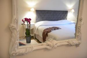 a bedroom with a bed and a mirror on a table at Hotel du Soleil et Spa in Saint-Rémy-de-Provence +30 photos