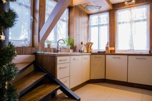kuchnia z drewnianymi ścianami i oknami oraz klatką schodową w obiekcie Domek Dzika Róża w Szklarskiej Porębie