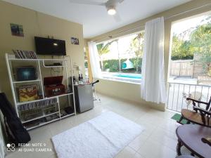 a living room with a tv and a large window at Paraiso Hortensia Ecolodge in Santiago de los Caballeros