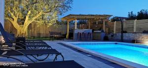 a swimming pool with chairs next to a fence at Apartment Brioni Sea,Garden,Poll view 2 plus 2 80m2 tiki bar in Peroj