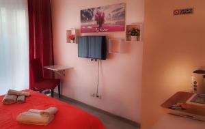 a bedroom with a red bed and a tv on the wall at A un passo dal centro in Palermo