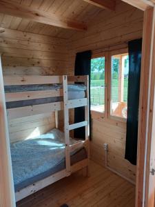 a room with two bunk beds in a log cabin at Domki nad stawem in Sambród