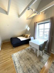 Habitación con cama, mesa y ventana en Presttind - Studio apartment with free parking, en Narvik