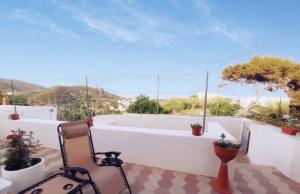 a balcony with a chair and potted plants at The Quiet House in Ponza