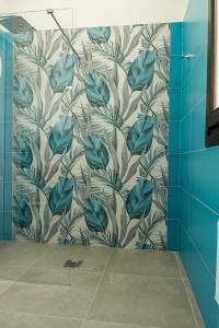 a bathroom with a mural of leaves on a wall at ANNICRU' AFFITTACAMERE in Castellammare del Golfo
