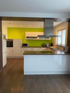 a kitchen with a white counter and a yellow wall at Julias Ferienwohnung in Wetzlar