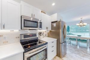 a kitchen with white cabinets and a microwave and a refrigerator at Brooks Lake House in Christina