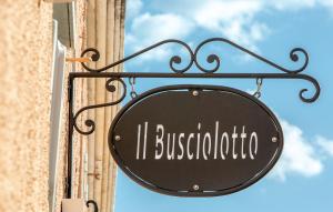 czarny znak przymocowany do boku budynku w obiekcie Il Busciolotto w mieście Santa Teresa Gallura