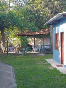 een tuin met een tuinhuisje met stoelen en tafels bij Suites para casais na praça Oswaldo Cruz in Cabo Frio