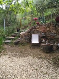 escalera de piedra con silla y pared de piedra en Au Cabanon Chez Nath - chbre d'hôtes - gîte, en Varages