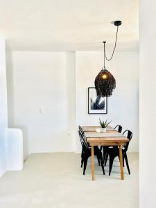 ein Esszimmer mit einem Holztisch und Stühlen in der Unterkunft Sun House Paros in Kampos Paros