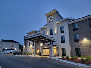 um hotel com uma placa na frente em Sleep Inn & Suites - Coliseum Area em Greensboro
