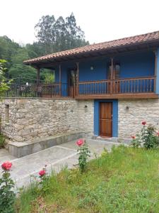 Casa azul con balcón y rosas rojas en Madre Rosa I, casa rural con la playa a 12 km, en Llanes