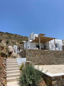 a house with a stone wall and stairs in front at Sun House Paros in Kampos Paros