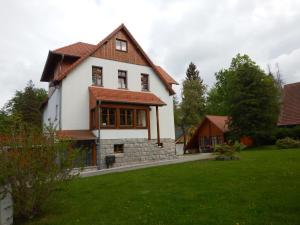 a white house with a brown roof at Domek Dzika Róża in Szklarska Poręba