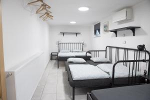 three beds in a room with white walls at Apartma Licko in Domžale