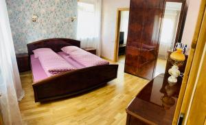 um quarto com uma cama com lençóis cor-de-rosa e uma mesa em Gemütliches Apartment mit Kamin und Wohnküche em Herzberg am Harz